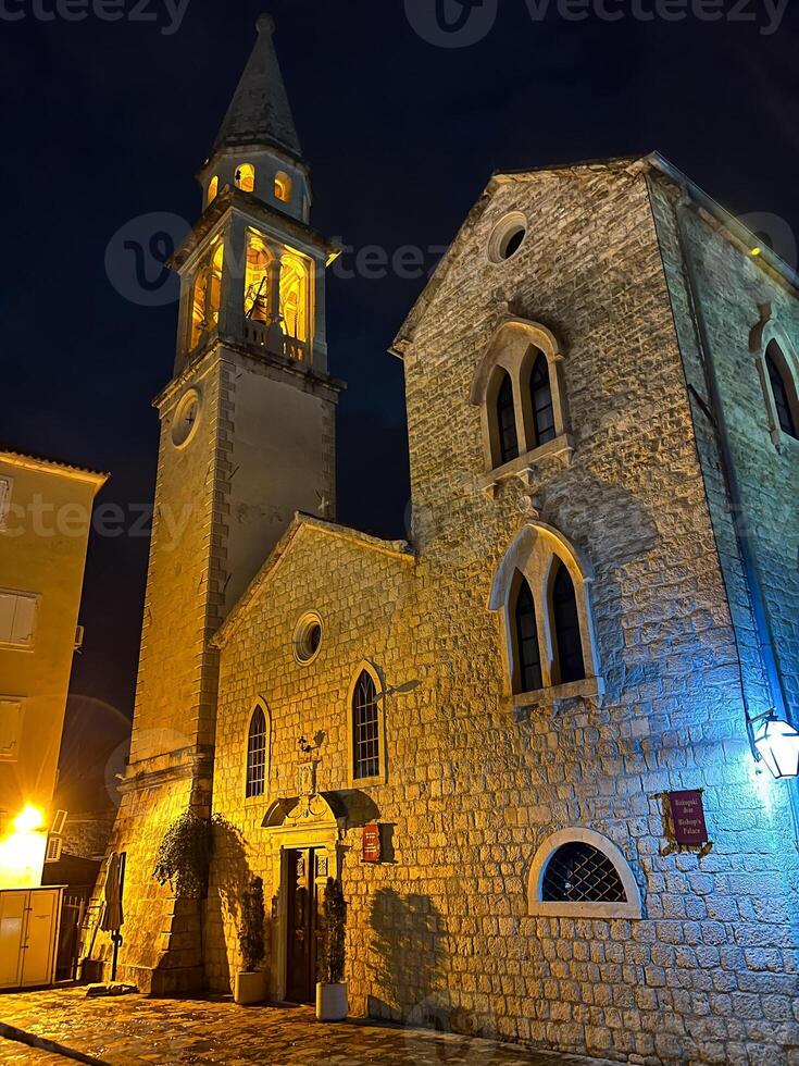 Roca catedral de S t. Juan en el iluminación de linternas a noche. buda, montenegro foto