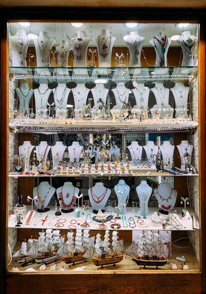 Budva, Montenegro - 25 december 2022. Jewelry shop window with jewelry and miniature models of sailboats photo