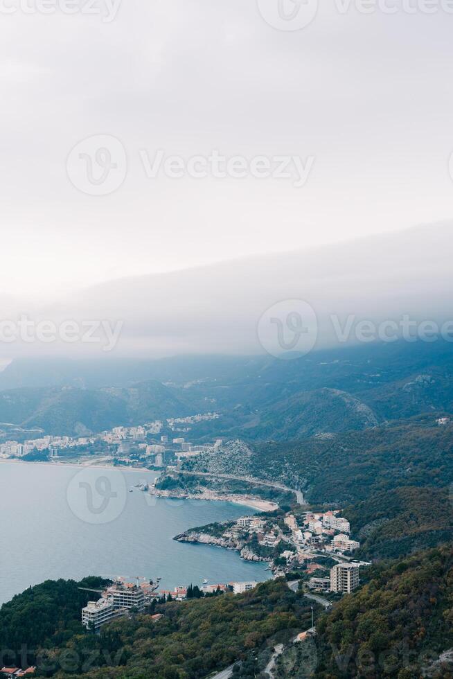 Multi-storey houses on the resort coast at the foot of the mountains in the fog photo