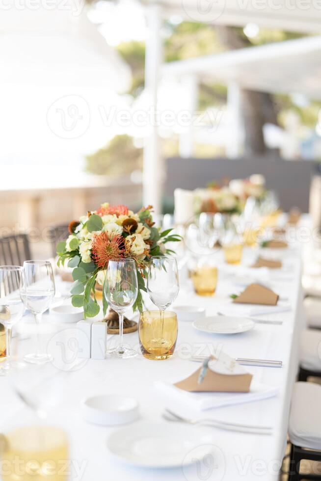 largo mesa conjunto con ramos de flores de flores y invitación suculentas foto