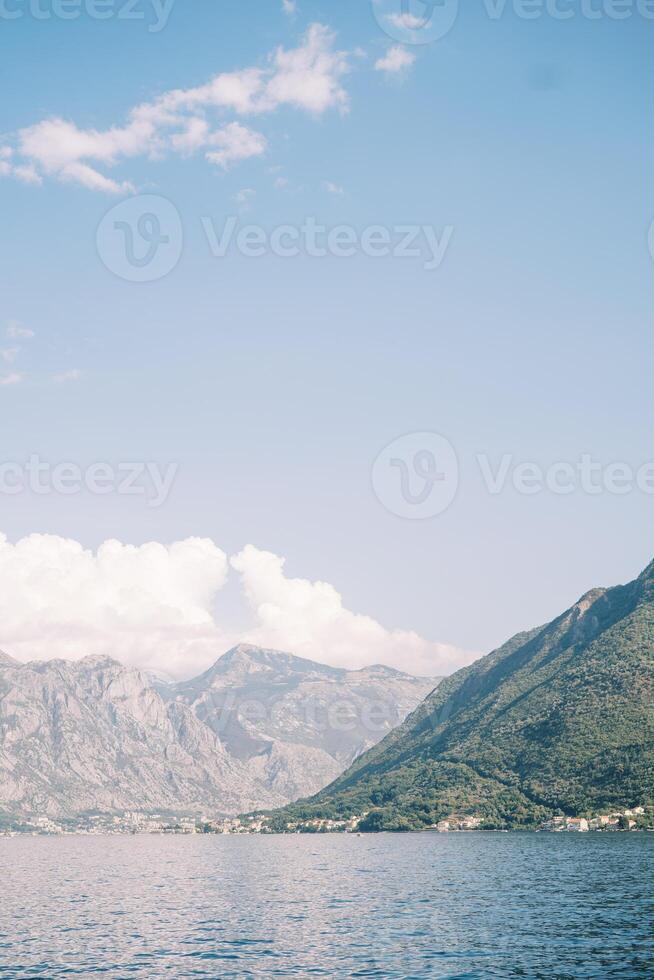 View from the sea to the mountainous coast in the sun photo