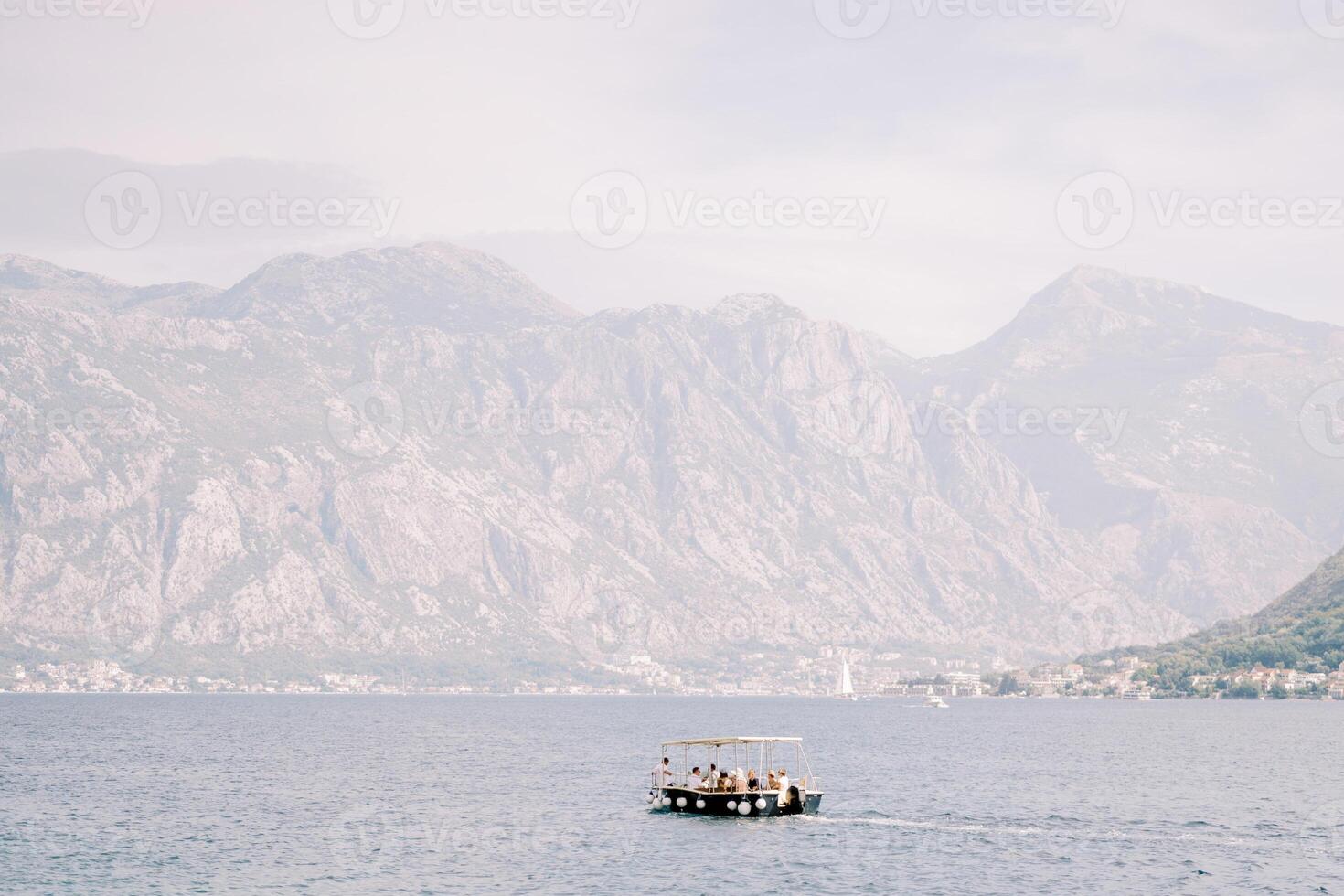 excursión barco paño en el mar en contra el fondo de un montaña rango en un ligero calina foto