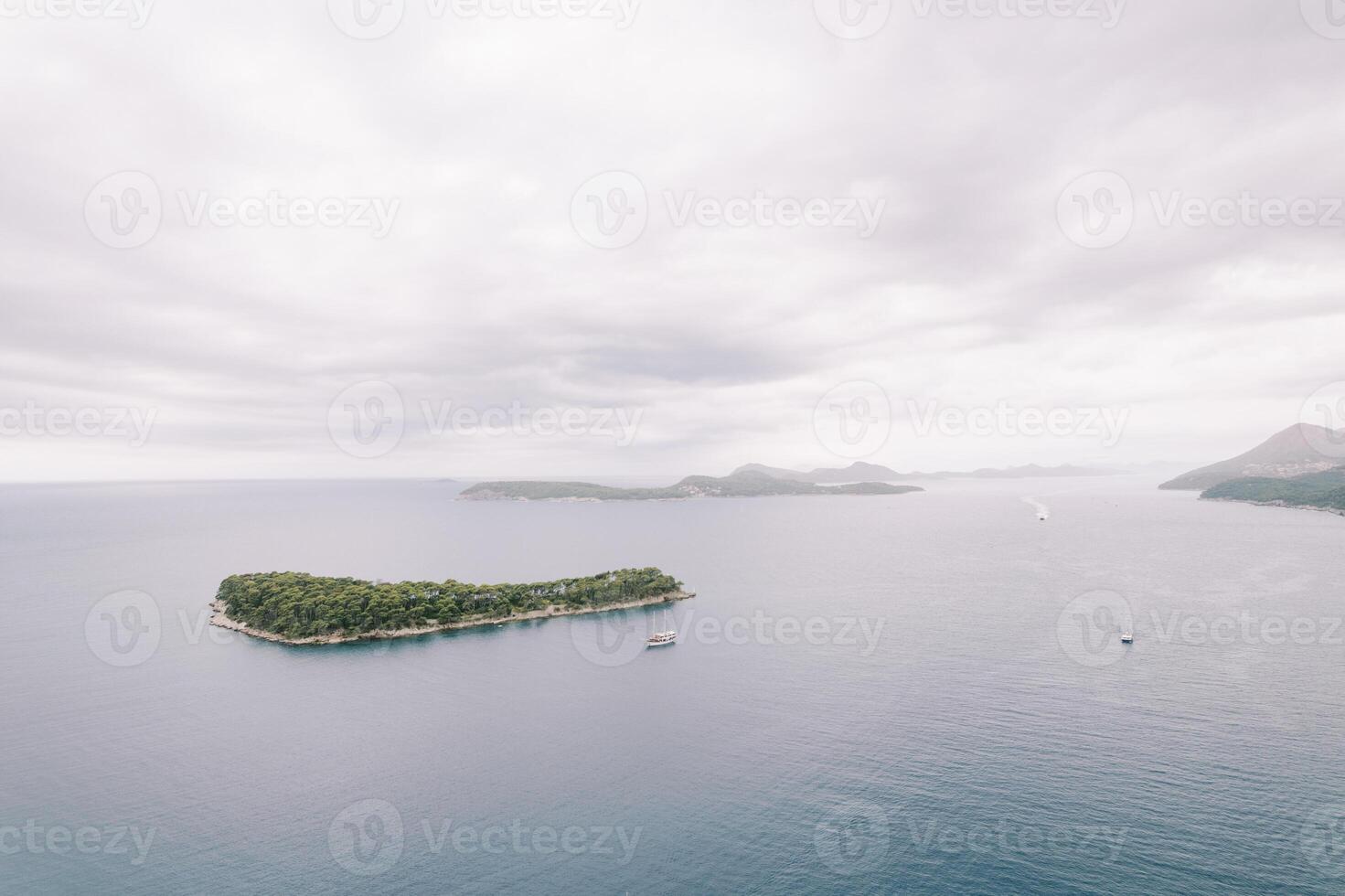 Ship sails past the green island of Daksa. Dubrovnik, Croatia. Drone photo