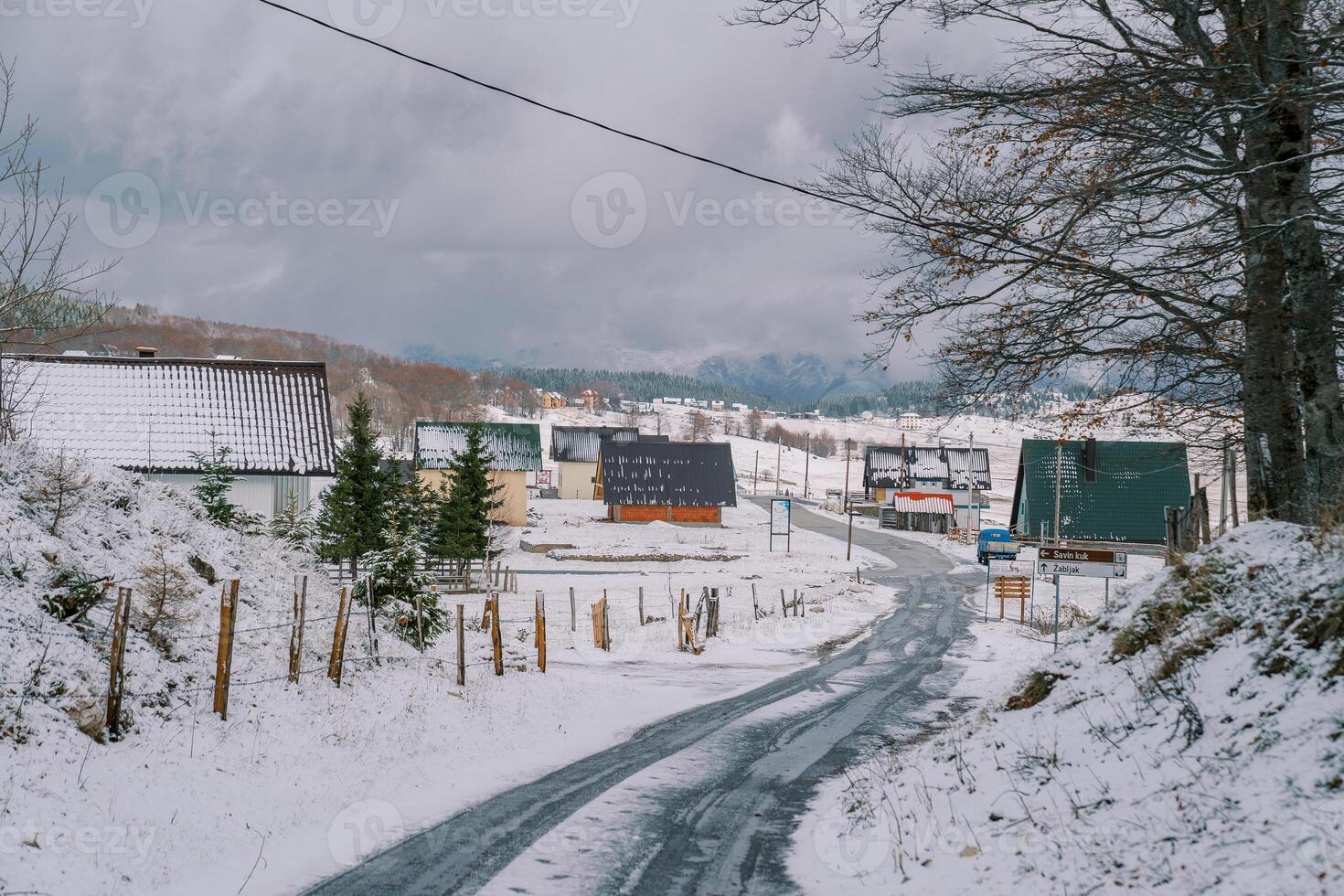 Snow-covered highway in a village with colorful houses in a mountain valley photo