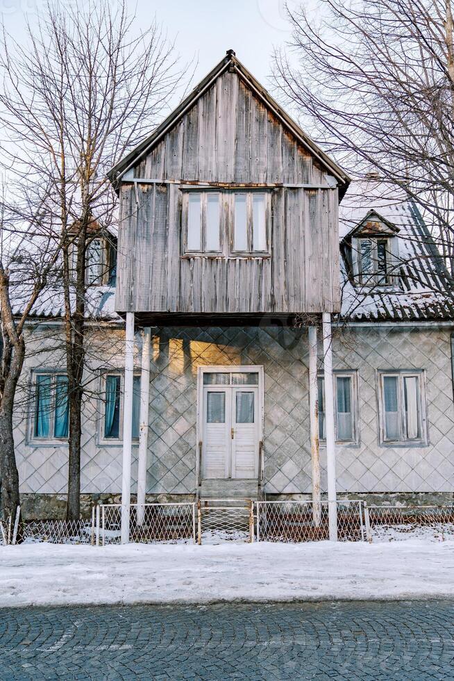 Triangular gazebo on stilts stands above the entrance to the house in the courtyard photo