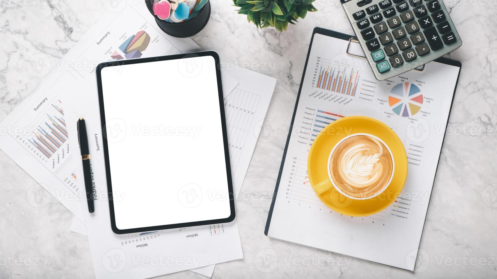 A tablet and a cup of coffee sit on a table with several pieces of paper. The scene suggests a moment of relaxation or contemplation photo