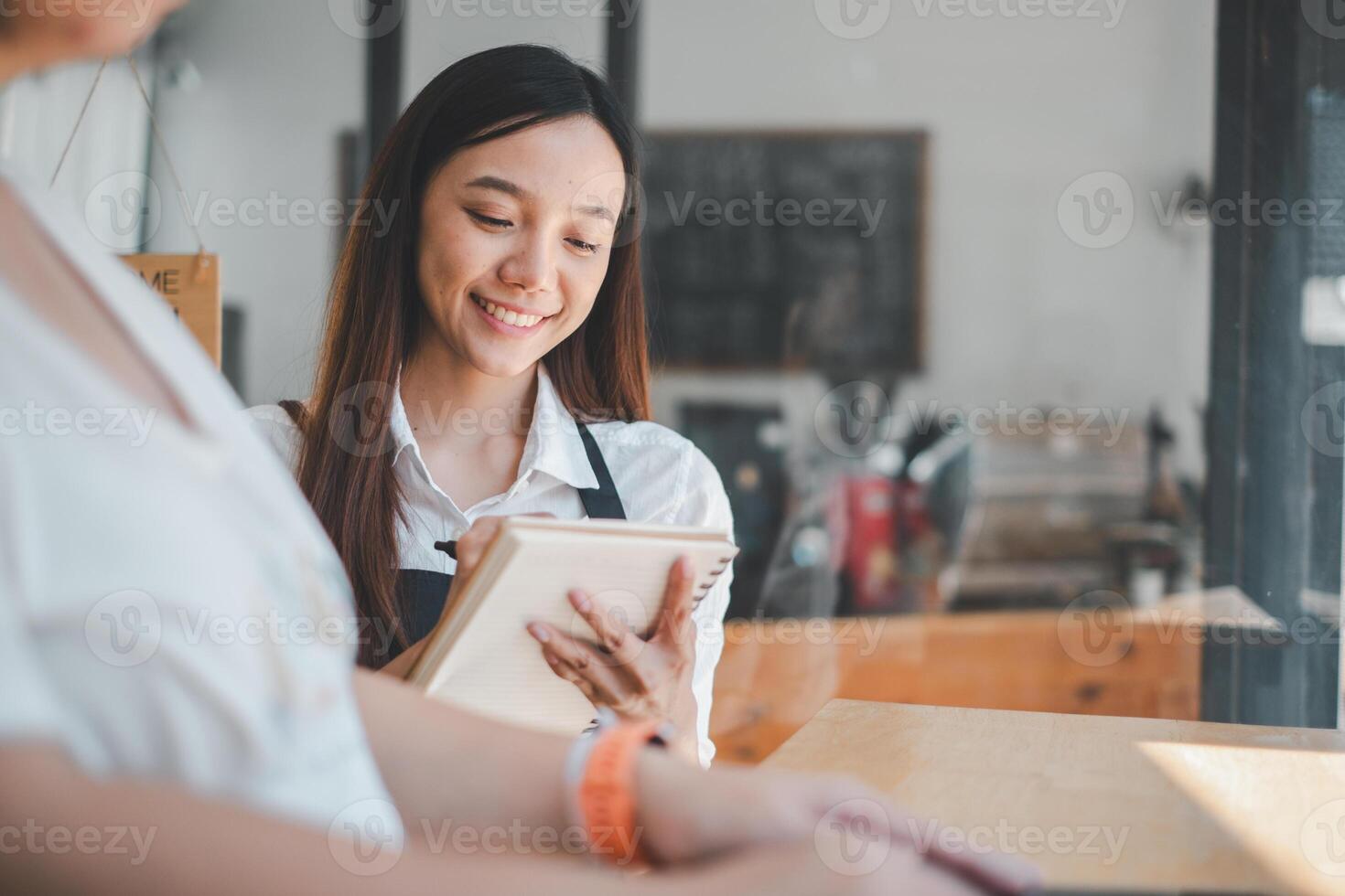 Attentive cafe worker taking a customer order, showcasing excellent service with a personal touch in a modern coffee shop. photo