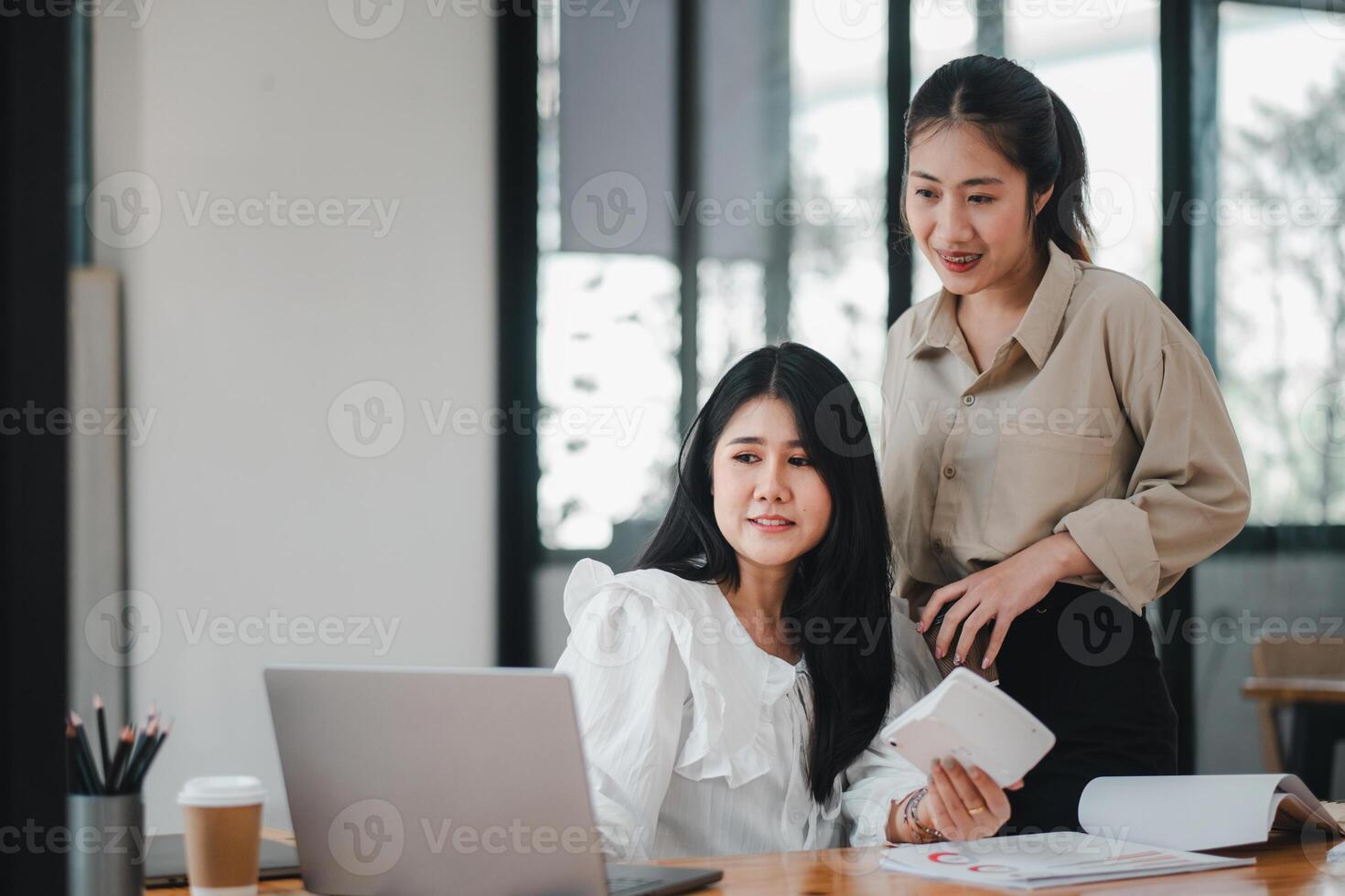 negocio equipo analítica concepto, alegre asiático mujer de negocios compartiendo documentos y ideas a un colaborativo oficina espacio de trabajo con un ordenador portátil. foto