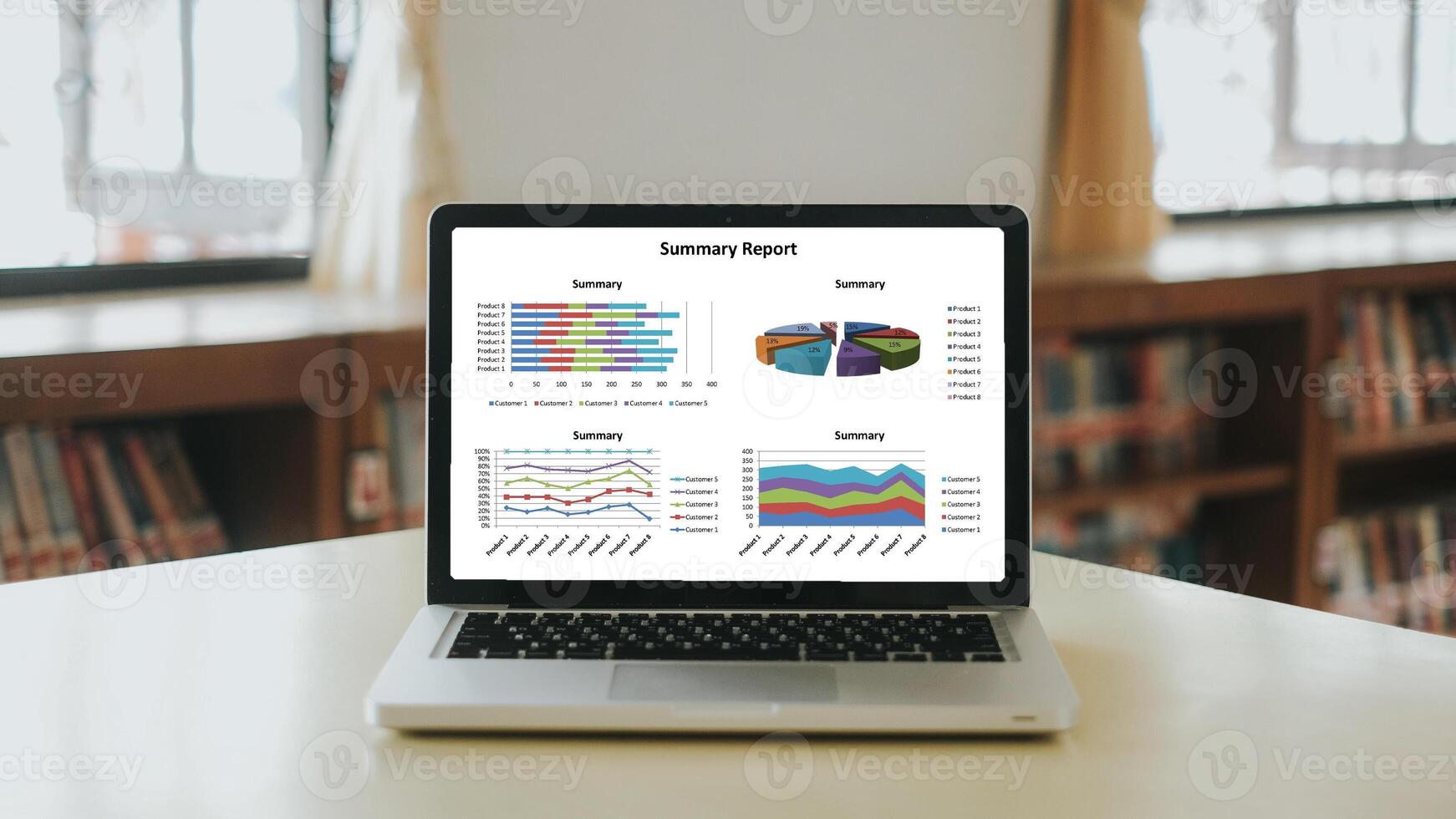 A laptop on a desk within a library environment, showcasing a detailed business summary report with various colorful charts and graphs on the screen. photo