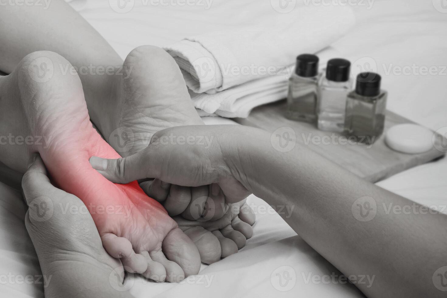 pie dolor, masajista manos cubrir mujer pies con herbario petróleo en cama a relajarse músculos desde suelas de pies. salud cuidado y pie medicina foto