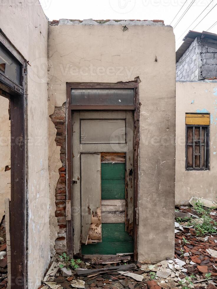 a broken door on a house that has been abandoned for a long time photo