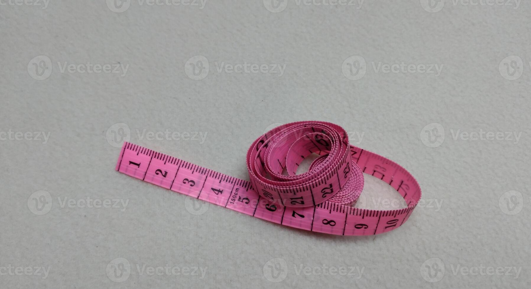 Pink measuring tape isolated on white background with copy space for text. photo
