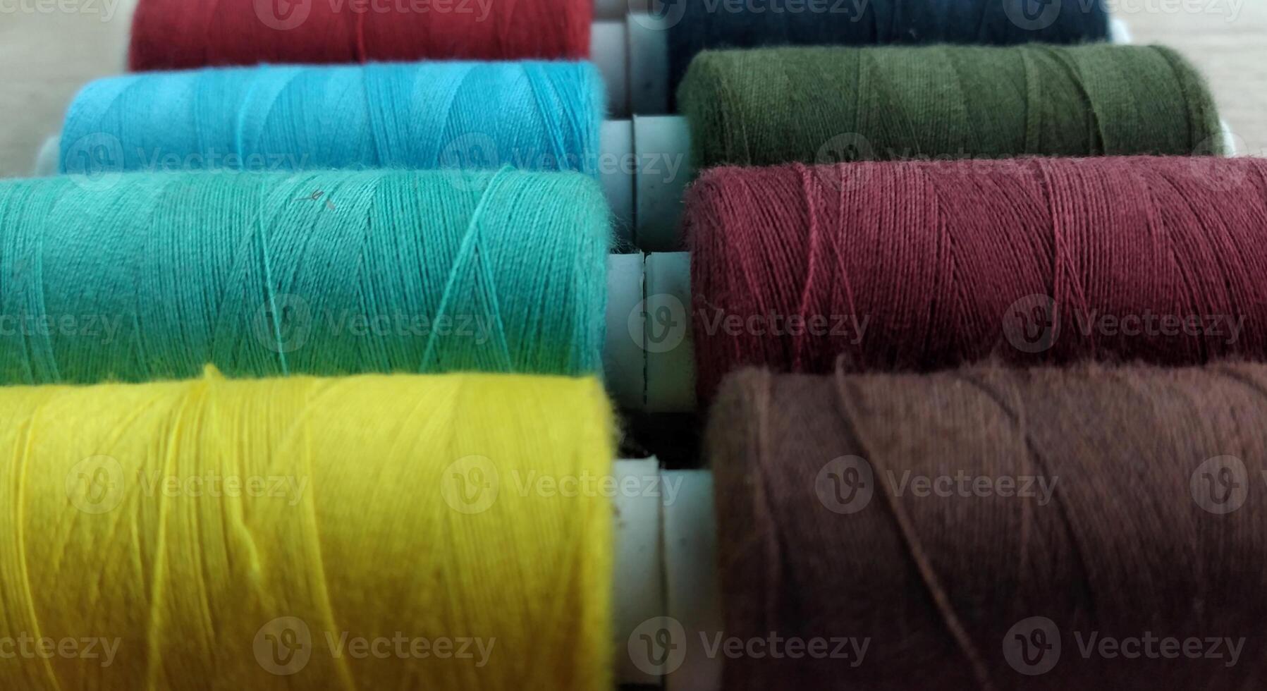 Spools of multicolored thread on wooden background with copy space photo
