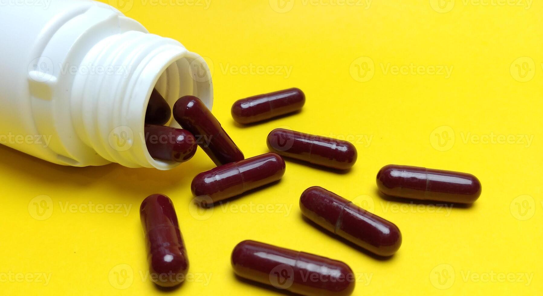 various kinds of pills arranged abstractly on a yellow background photo