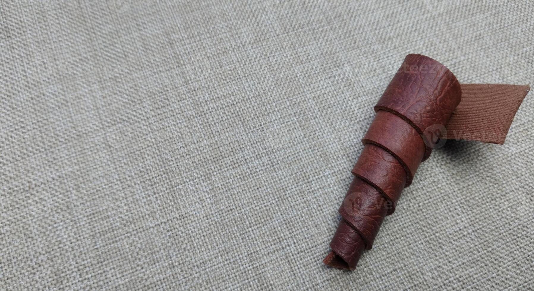 A piece of brown leather on a linen tablecloth with copy space photo