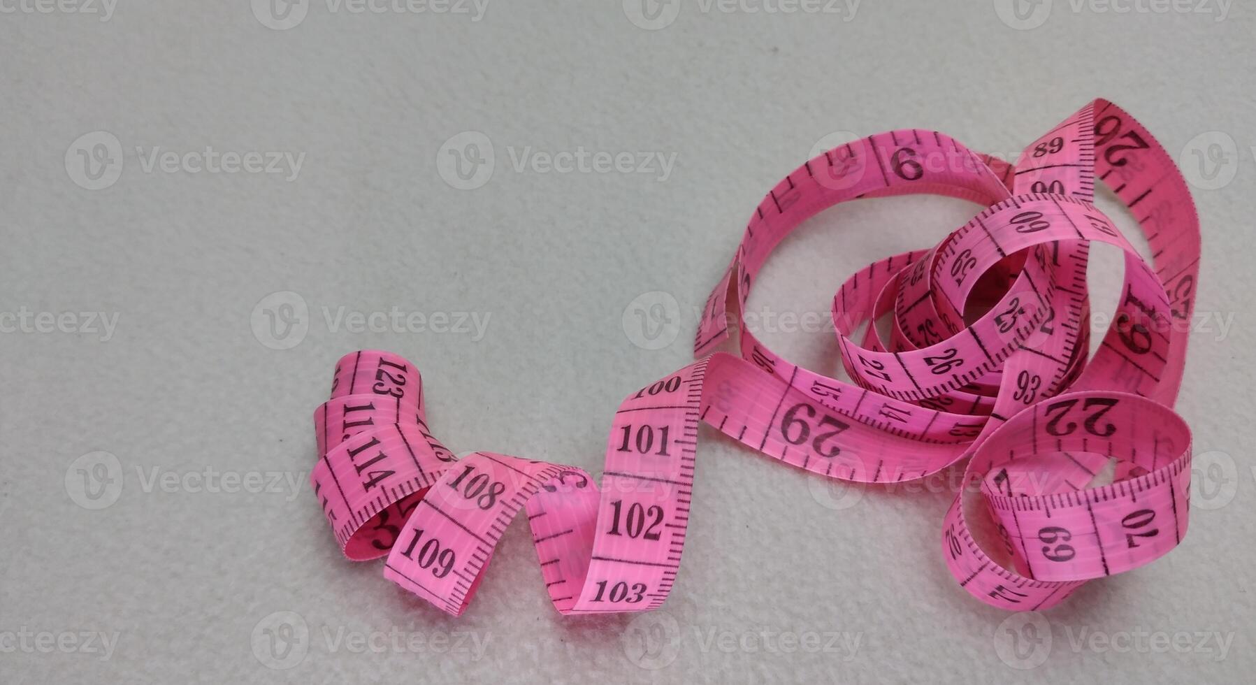 Pink measuring tape isolated on white background with copy space for text. photo