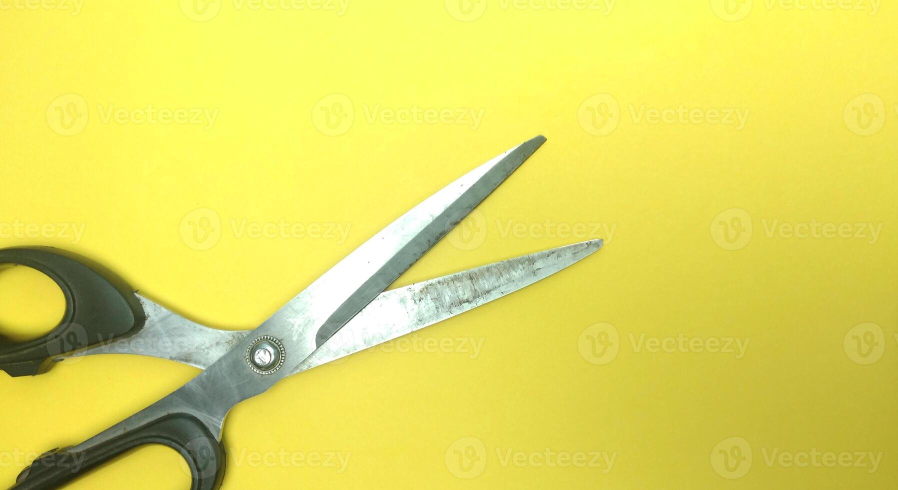 Old sewing scissors on a yellow background. View from above. Copy space. photo