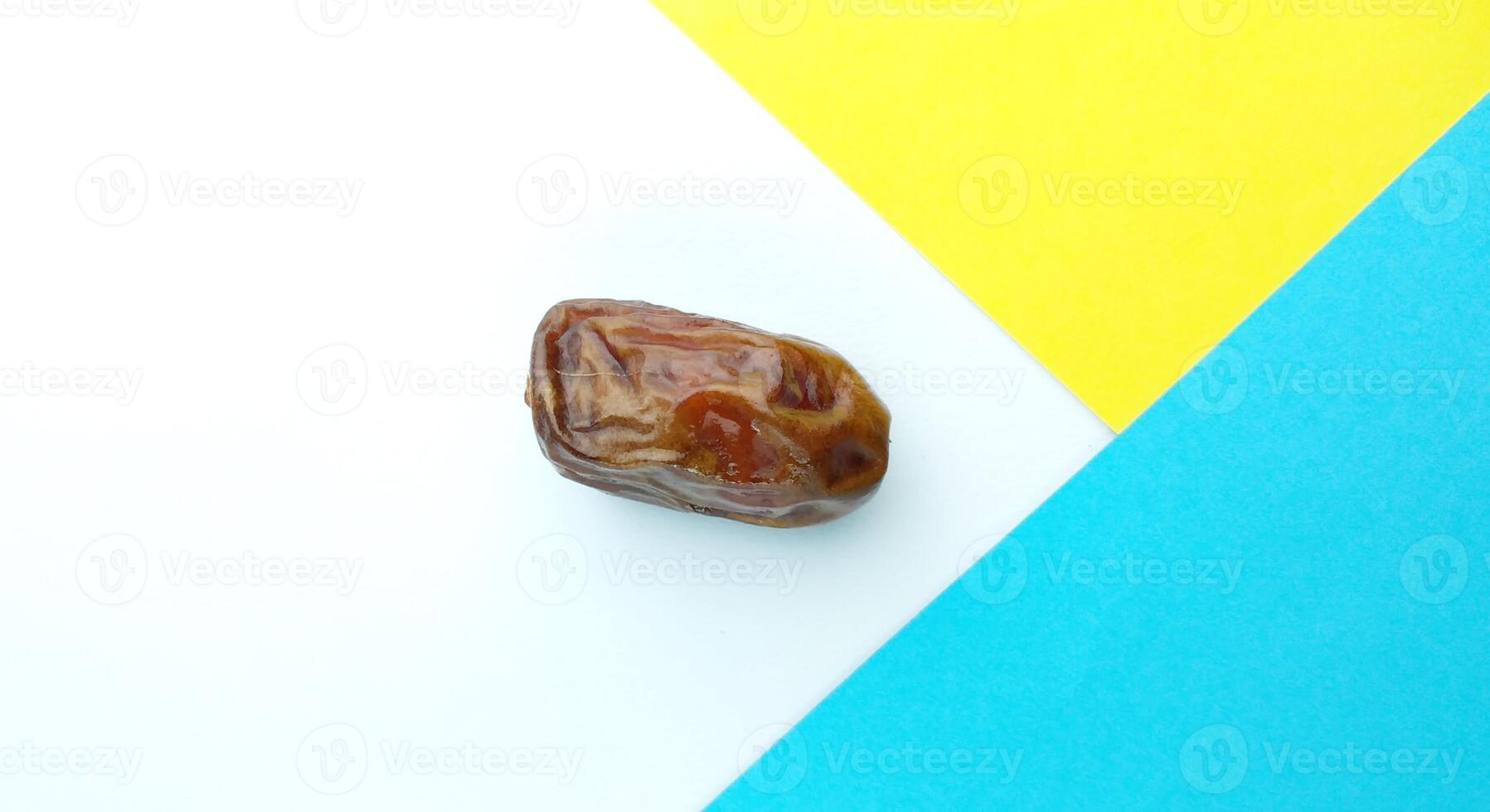 Date fruit on blue and yellow background. Top view. Copy space. photo