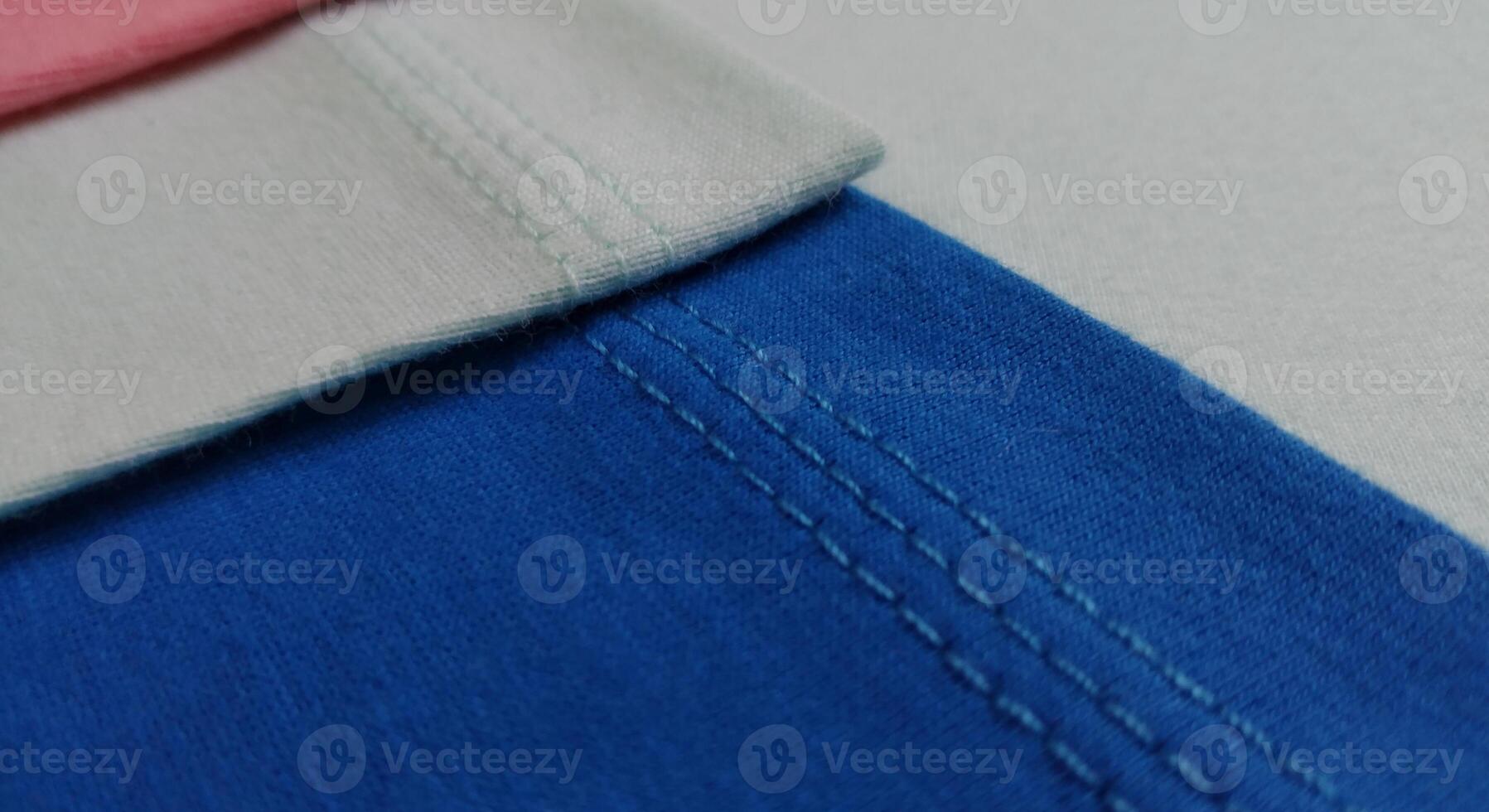 Fabric samples in different shades of blue and pink, closeup on green background photo