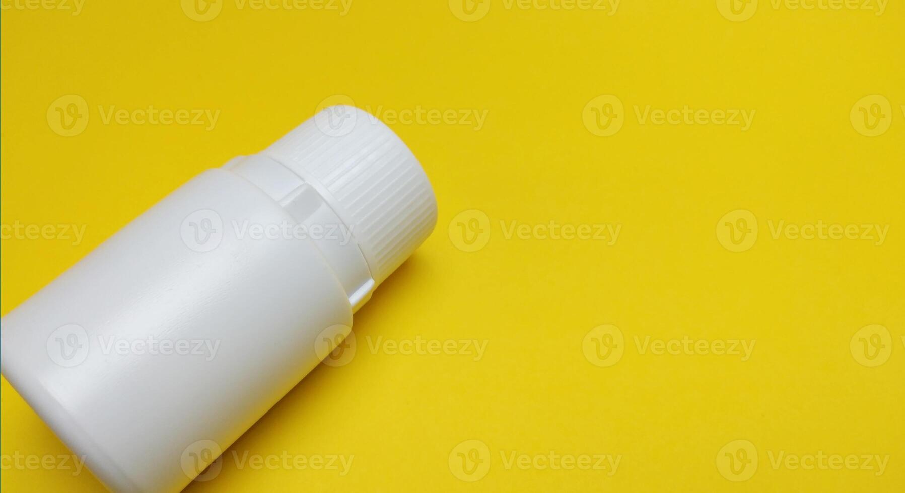 various kinds of pills arranged abstractly on a yellow background photo