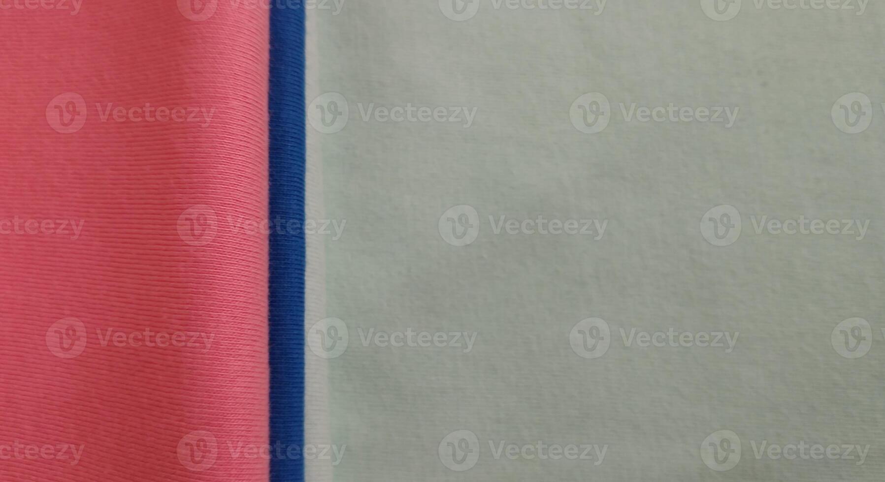 Fabric samples in different shades of blue and pink, closeup on green background photo