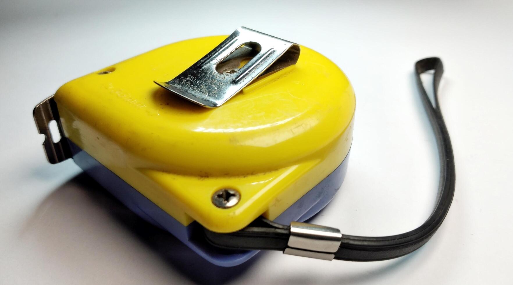 Yellow tape measure on a white background. Close-up. Selective focus. photo