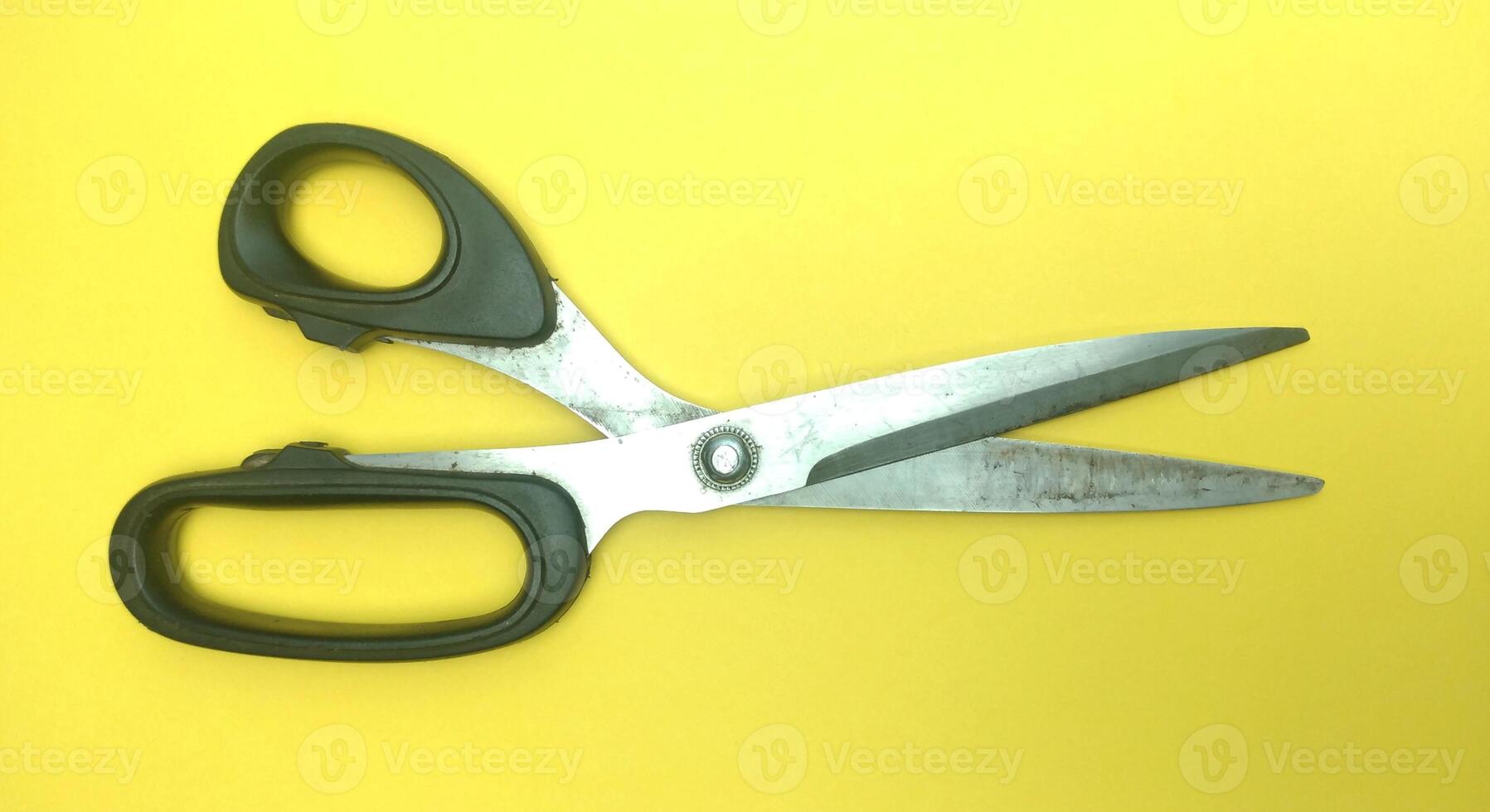 Old sewing scissors on a yellow background. View from above. Copy space. photo