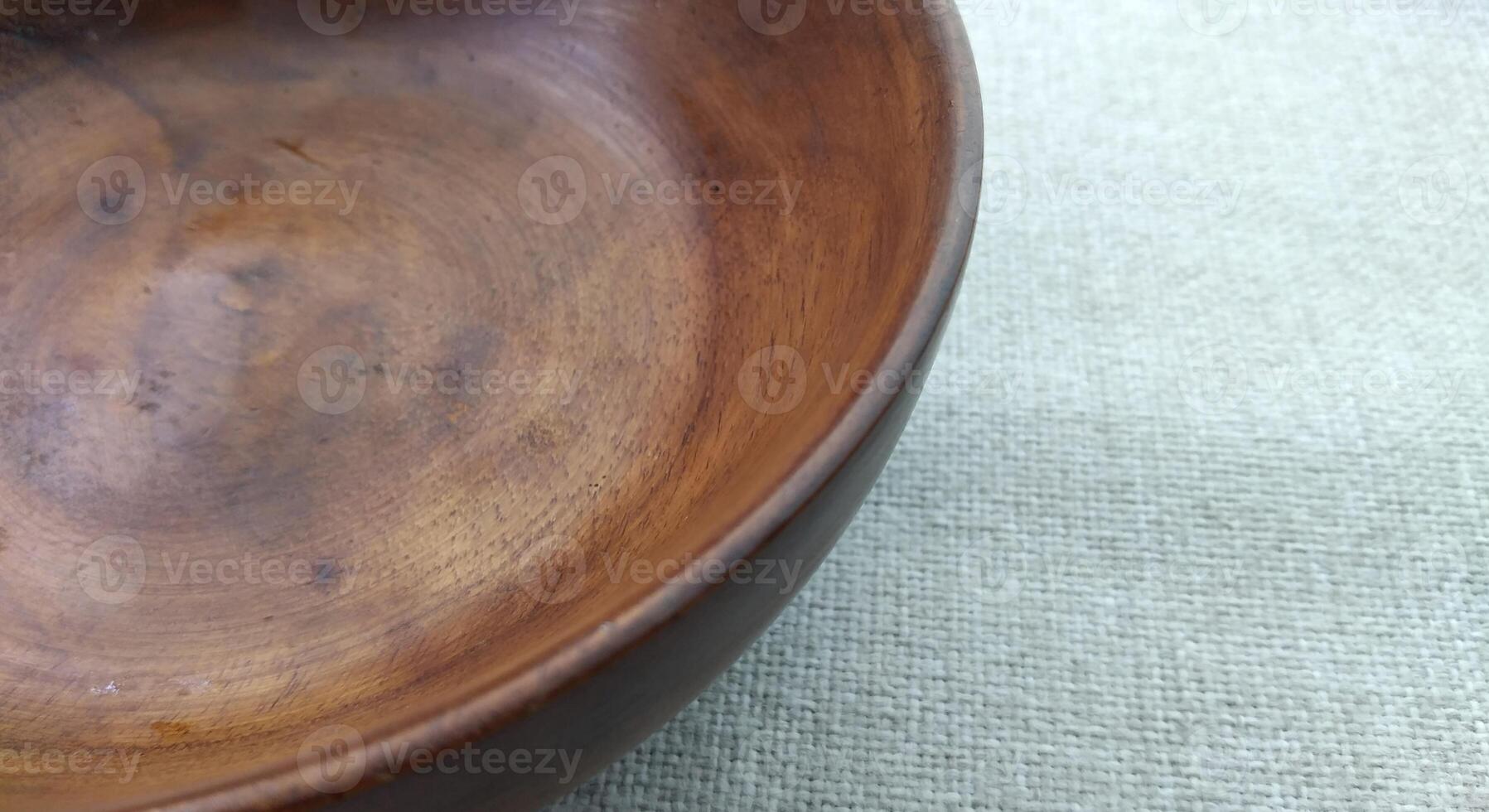 Empty wooden bowl on a linen tablecloth, top view, copy space photo