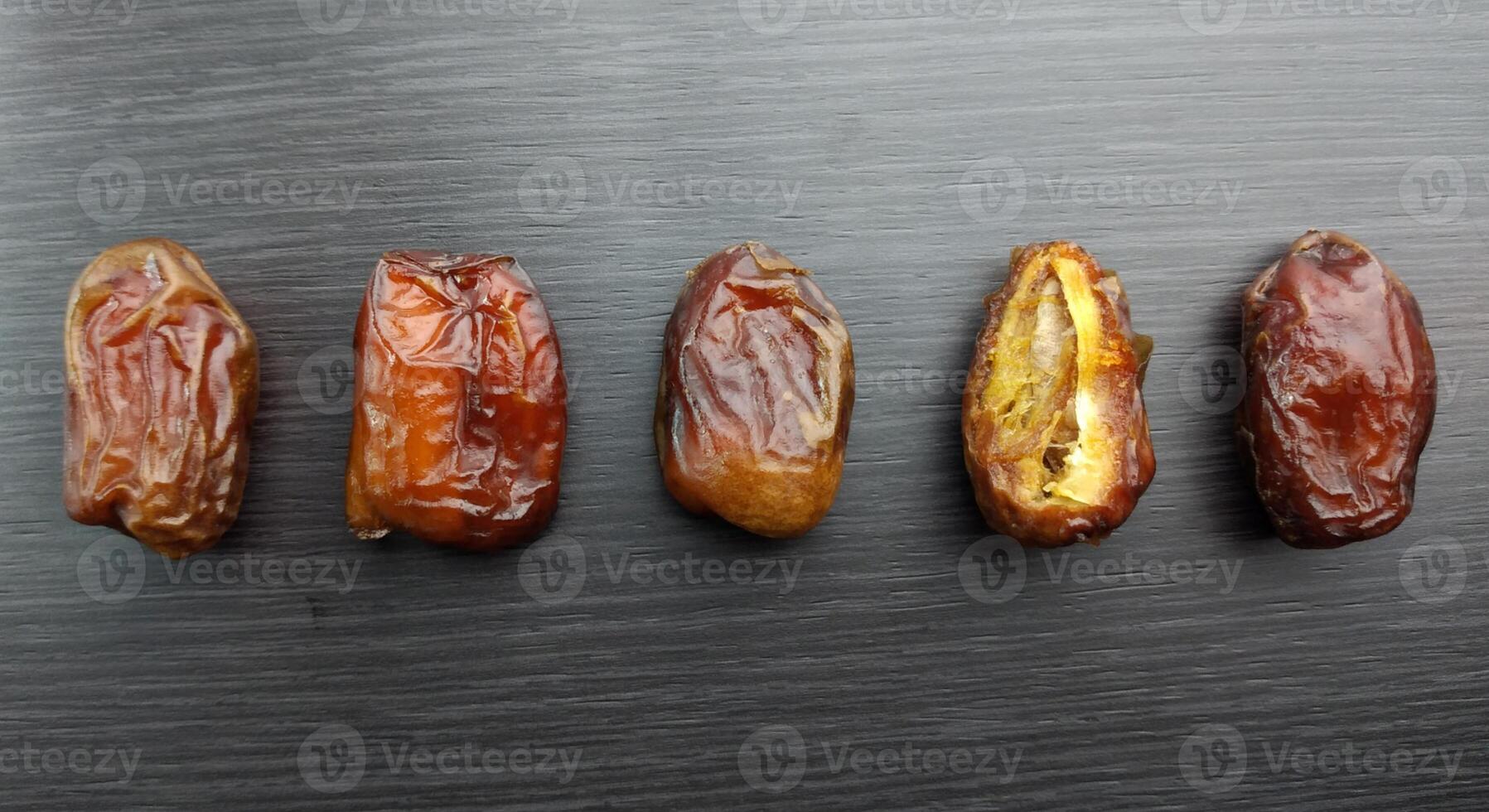 dried dates on a black background. Top view, flat lay photo