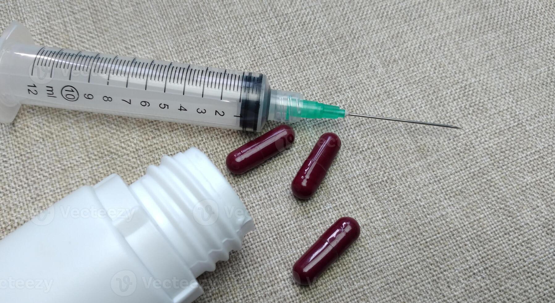 Medicine pills of various kinds and types with injections on a cloth background photo