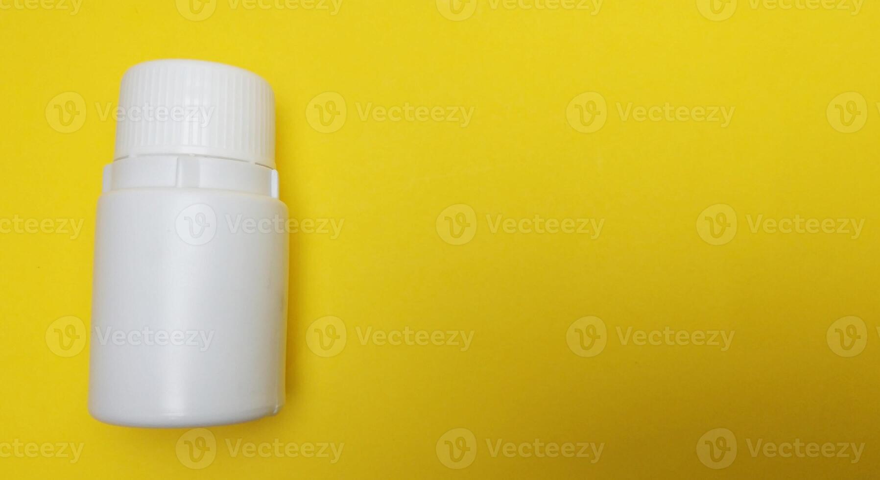 various kinds of pills arranged abstractly on a yellow background photo