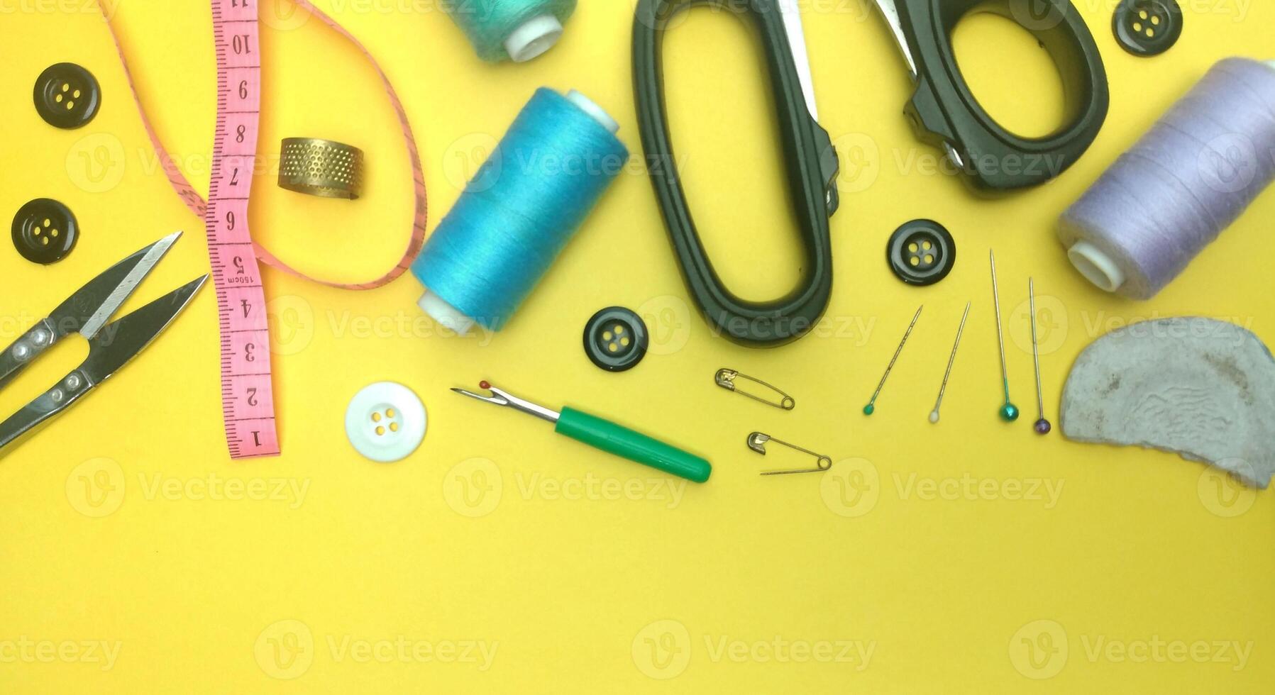 various sewing equipment seen from above on a yellow background photo