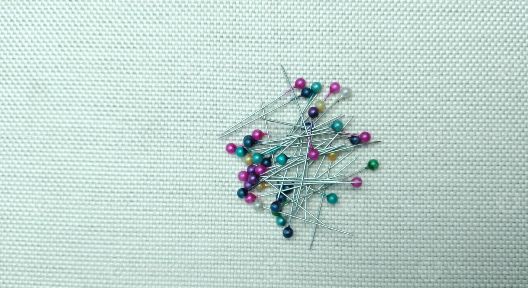colorful pins on fabric background. Sewing accessories on a white fabric background. photo