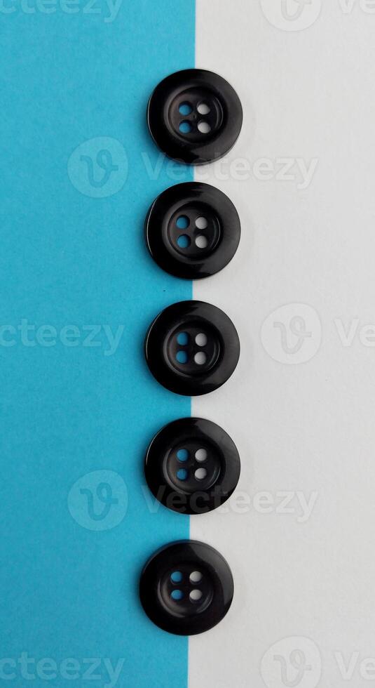 Black buttons on a white and blue background. Selective focus. photo