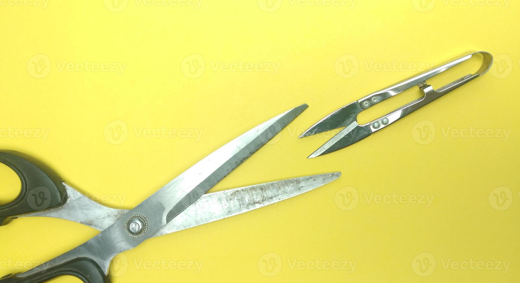 Old sewing scissors on a yellow background. View from above. Copy space. photo