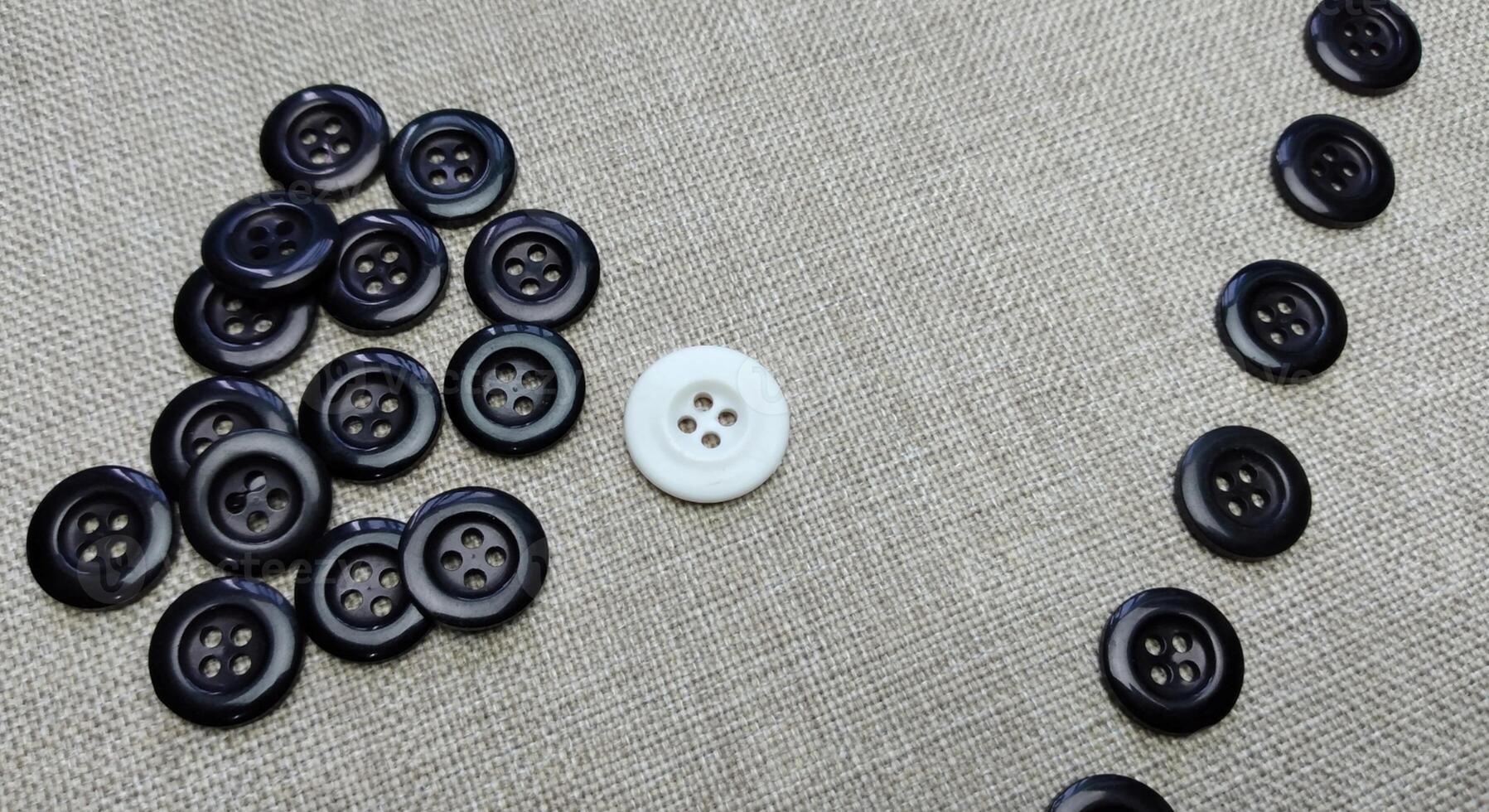 Black and white buttons on a linen cloth. Shallow depth of field. photo