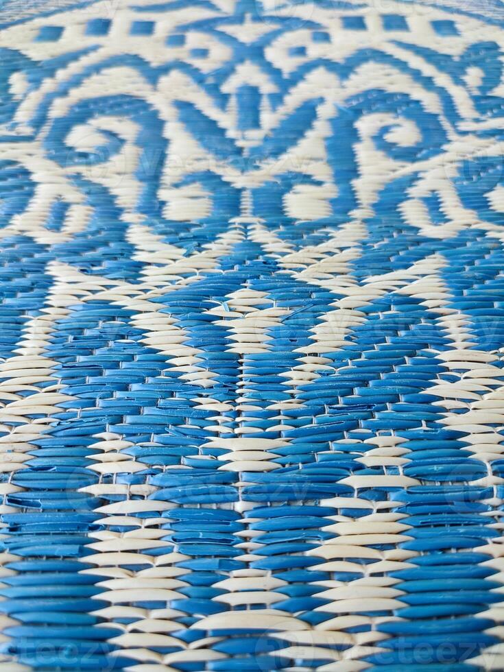 Blue and white woven mat with motif designs on it photo