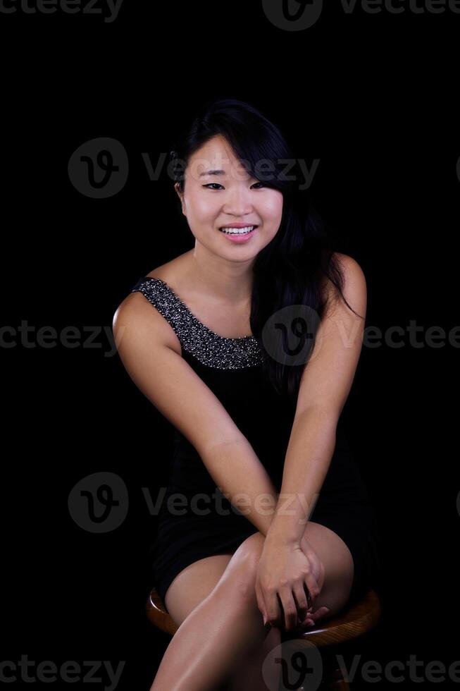 Young Attractive Japanese Woman Sitting On Black Background photo