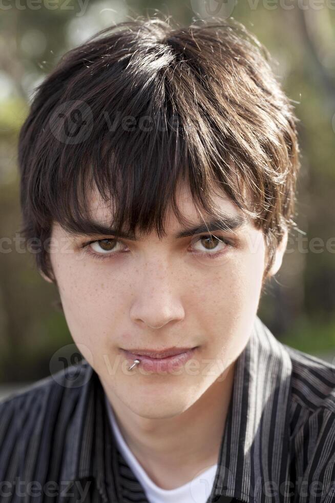 Outdoor portrait teen caucasian boy dark hair photo