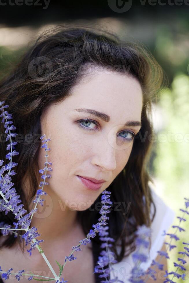 Outdoor portrait attractive young caucasian woman with flowers photo