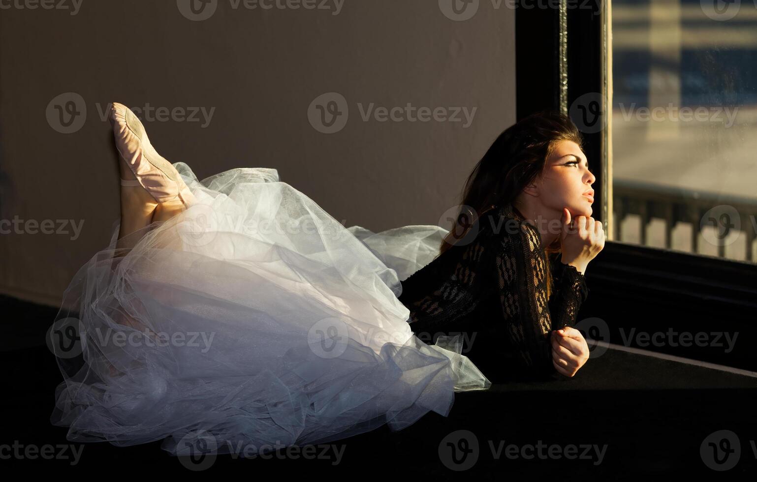 Pretty Woman In Dance Outfit Looking Out Window Laying Down photo