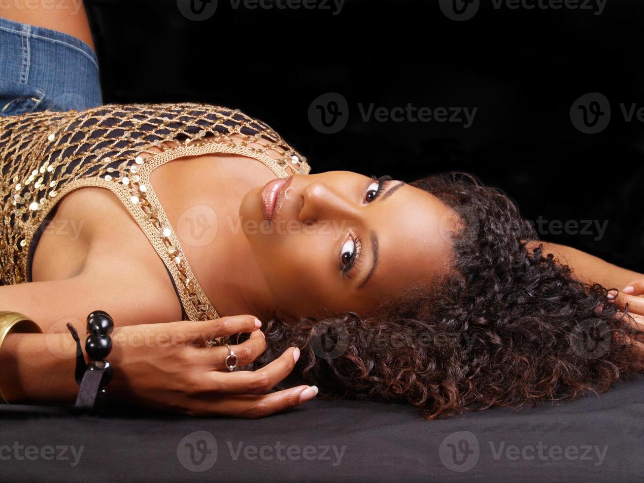 Young black woman reclining on back looking photo