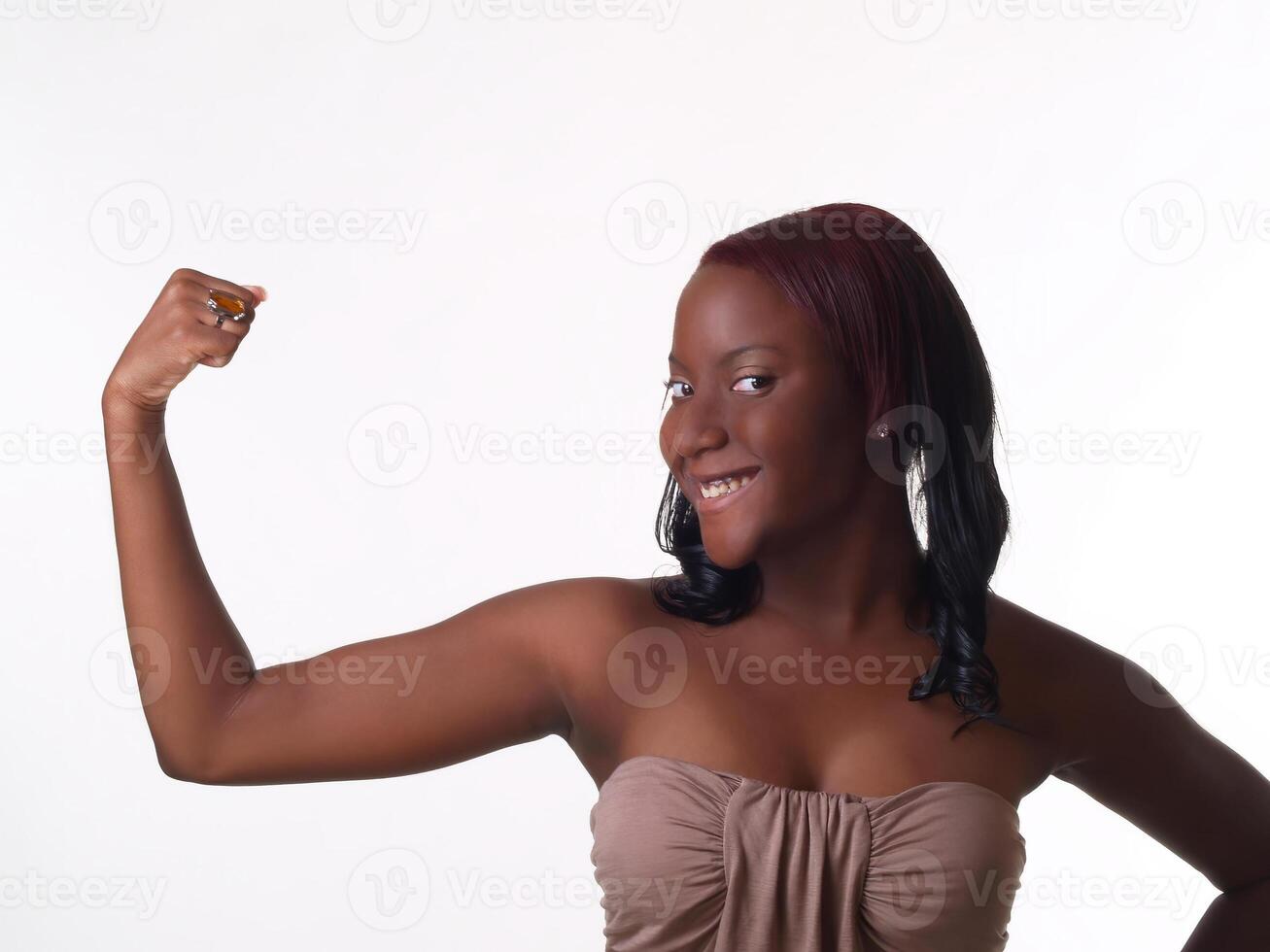 joven africano americano adolescente niña demostración bíceps en uno brazo foto