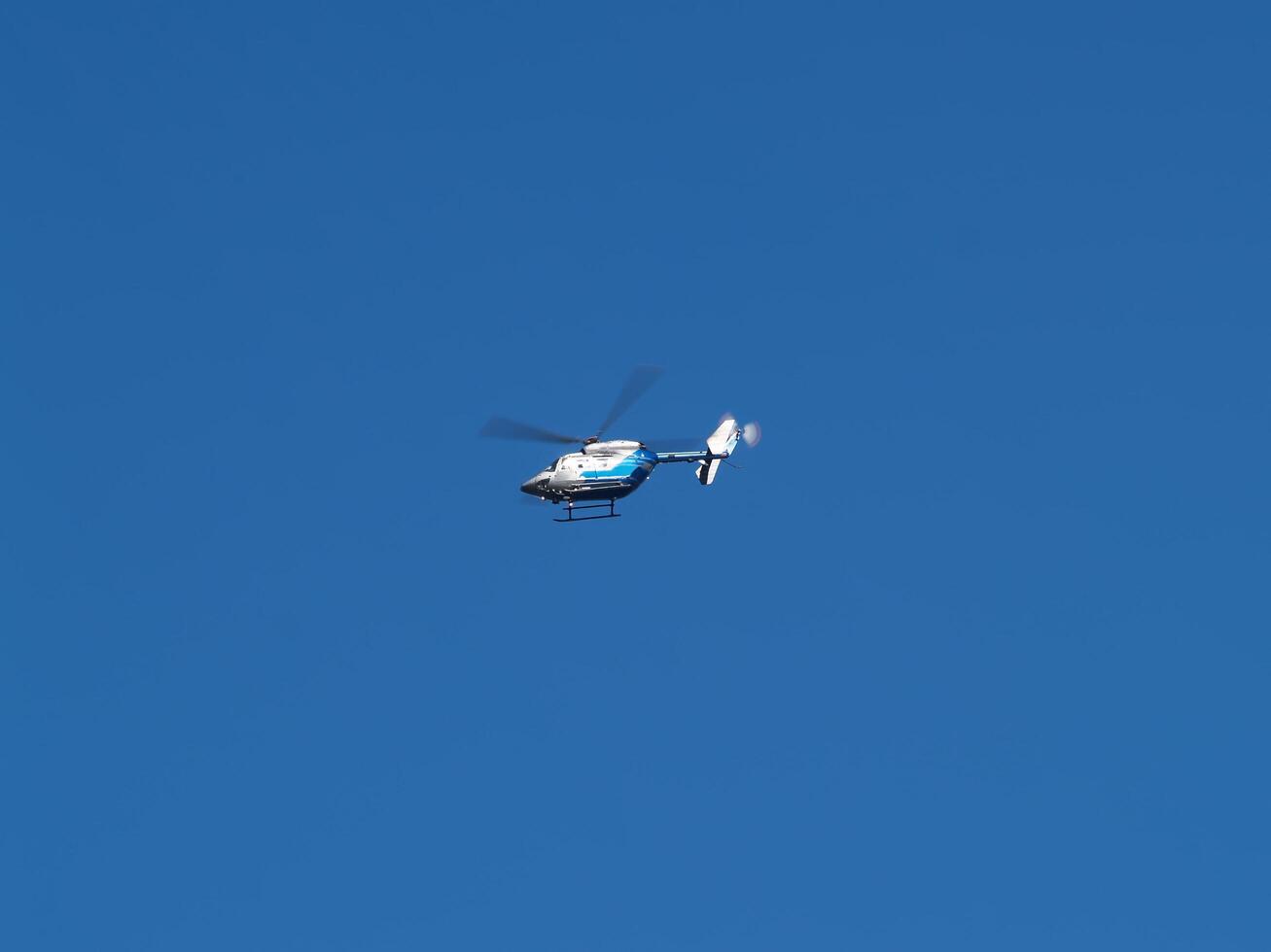 Boston, MA, 2008 - Small Medical Helicopter In Flight Against Blue Sky photo