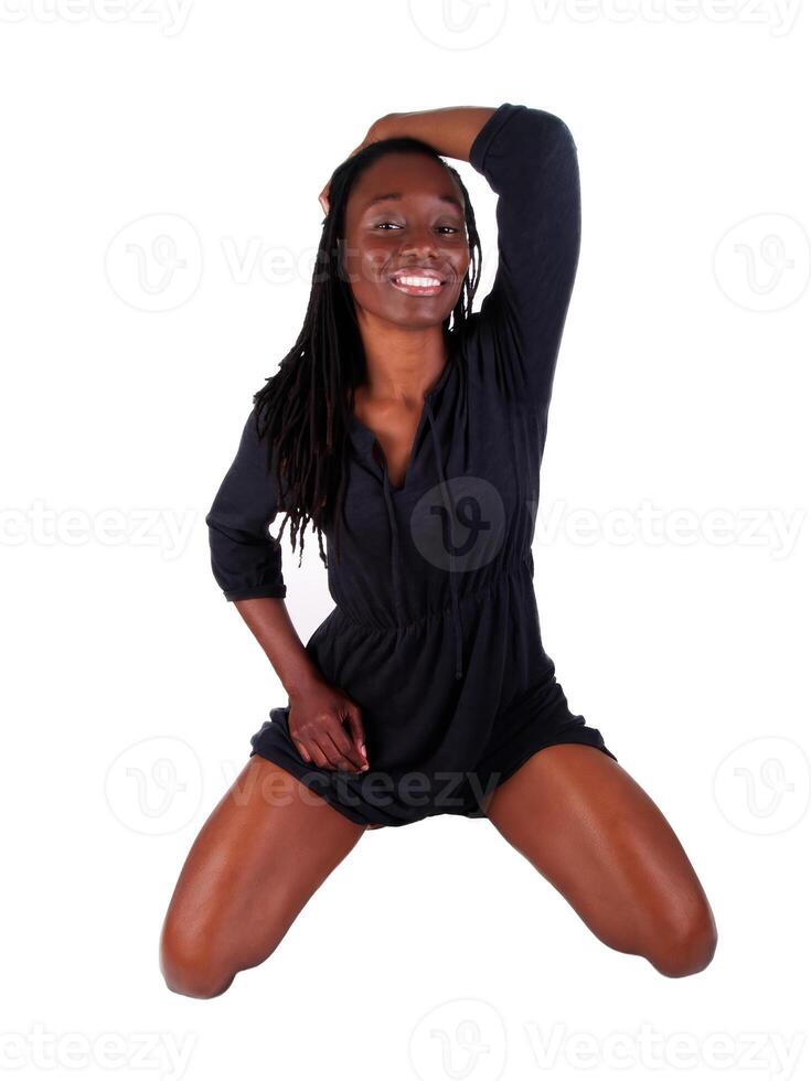 Smiling African American Woman Kneeling In Dress On White photo