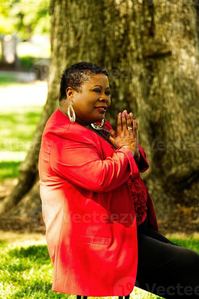 Older African American Woman Sitting Outdoors Red Jacket photo