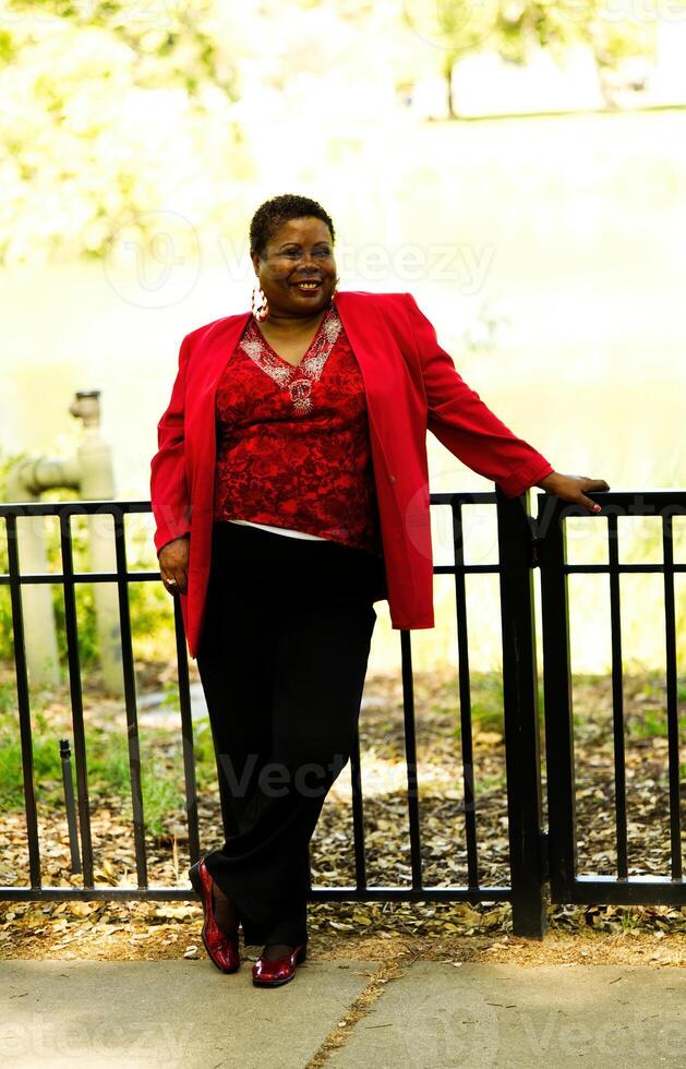 Middle-Aged African American Woman Standing Outdoors Red Top photo