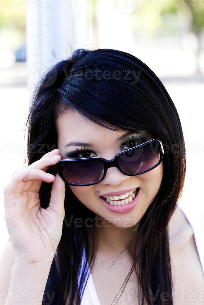 Outdoor Portrait Asian American Woman Peeking Over Sunglasses photo