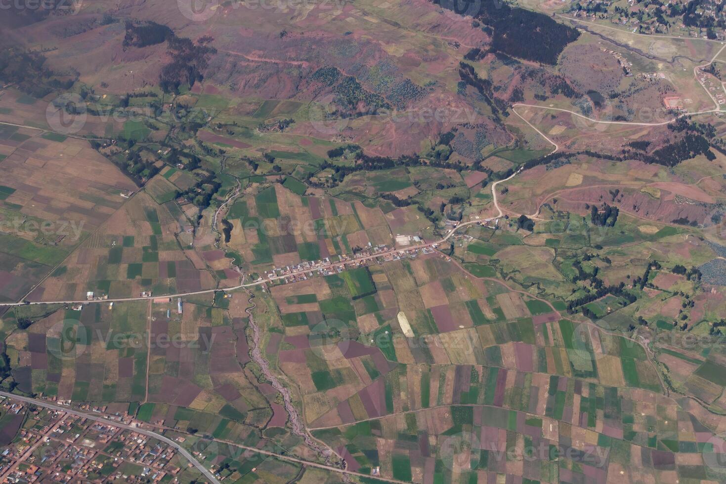 Aerial Shot Of Agricultural Fields And Small Village Along Road photo