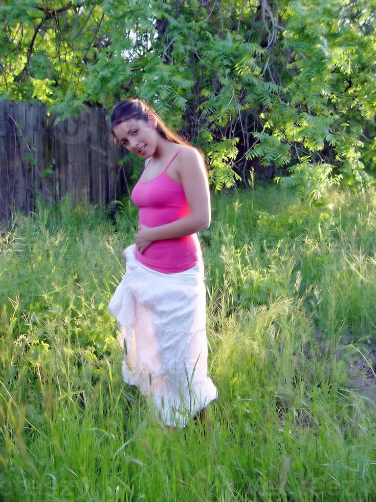 Caucasian Woman Standing In Green Grass White Skirt Red Top photo